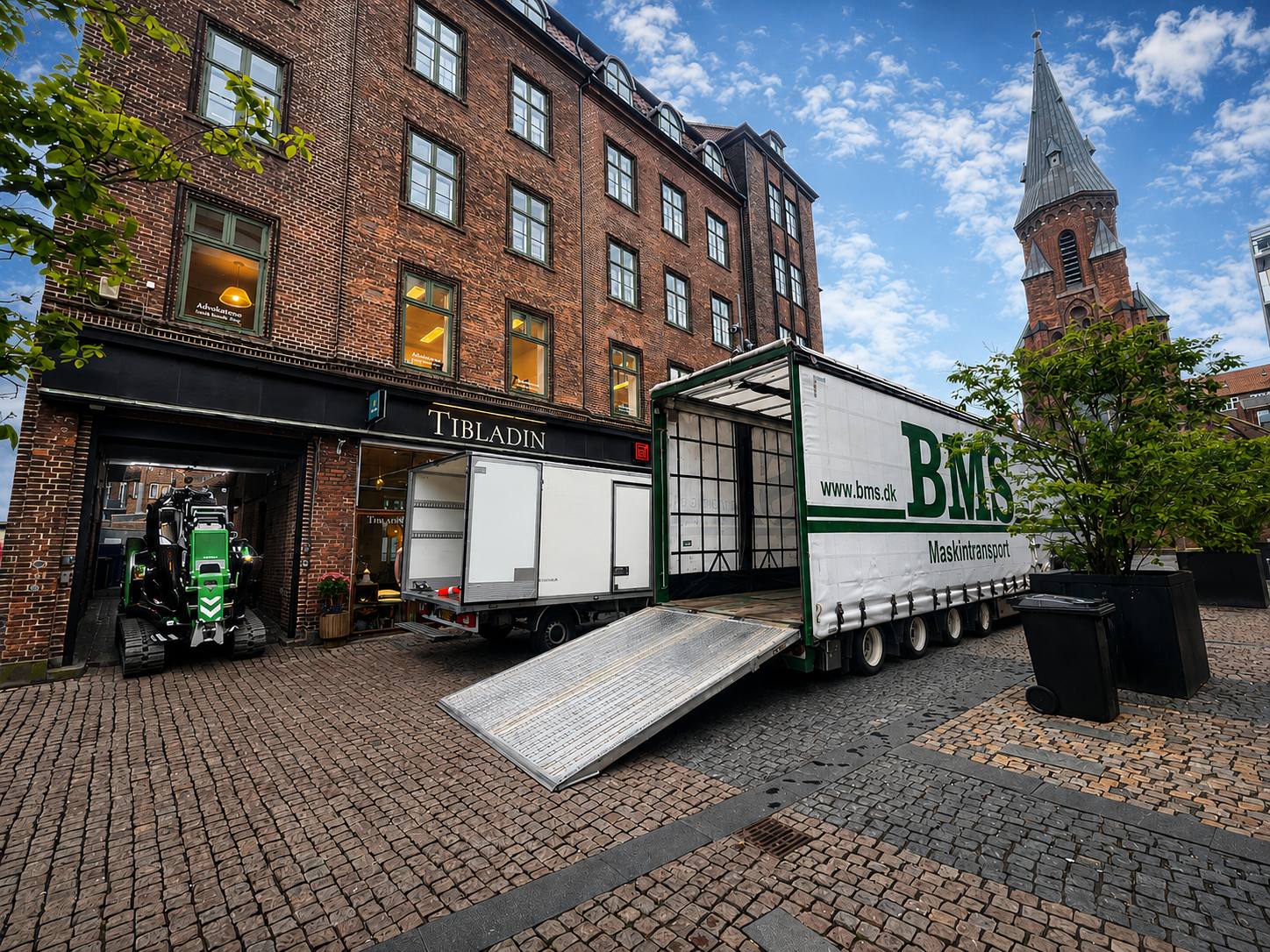 Minikran transporteres gennem en smal port til baggård i Aarhus.