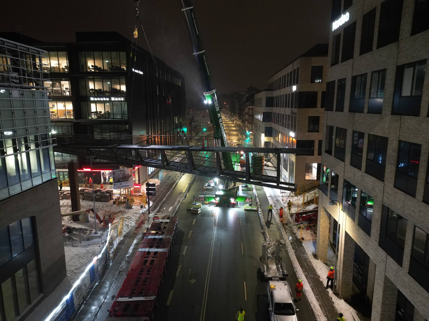Brosektion løftes på plads mellem bygninger ved Kulbroen i Aarhus om natten