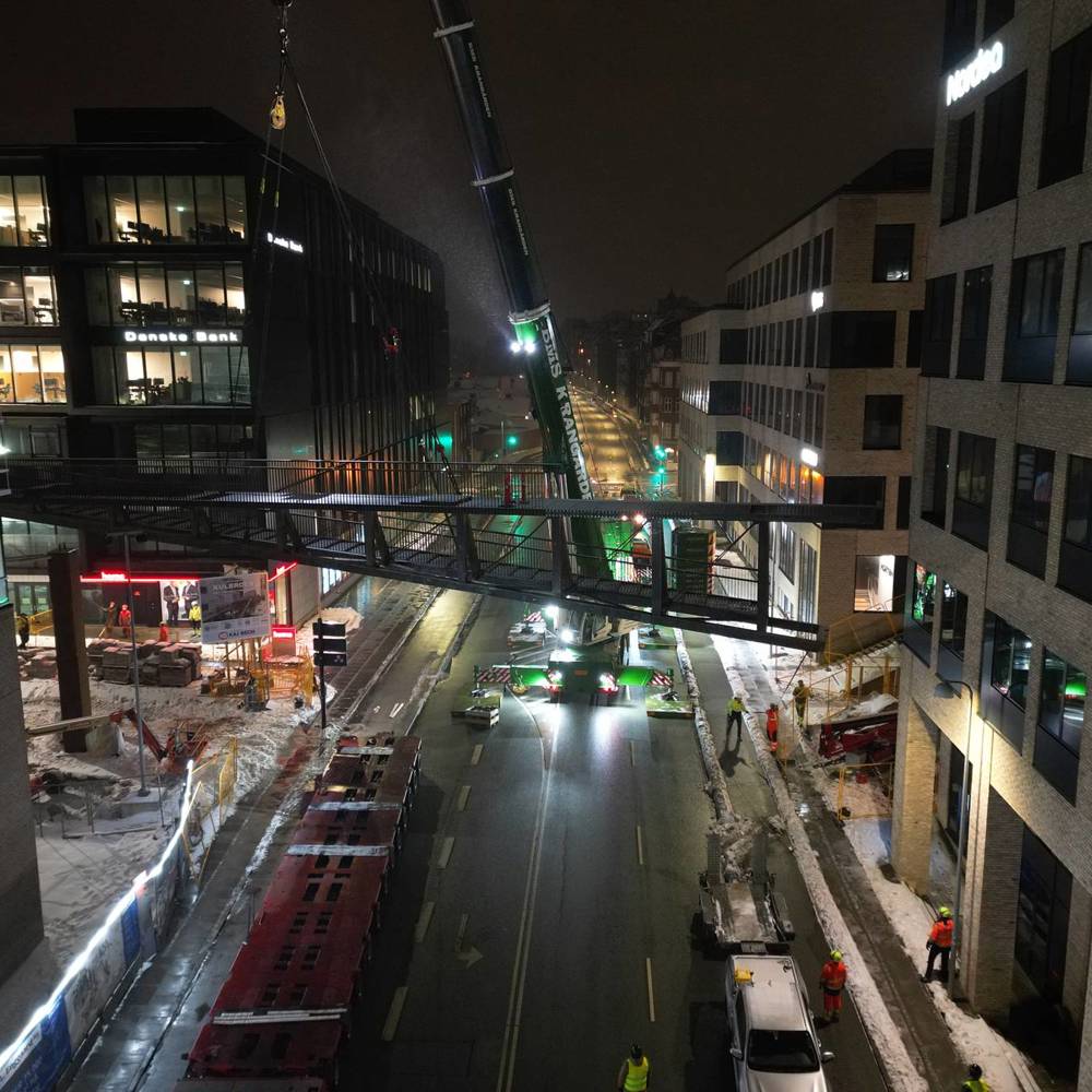 Brosektion løftes på plads mellem bygninger ved Kulbroen i Aarhus om natten