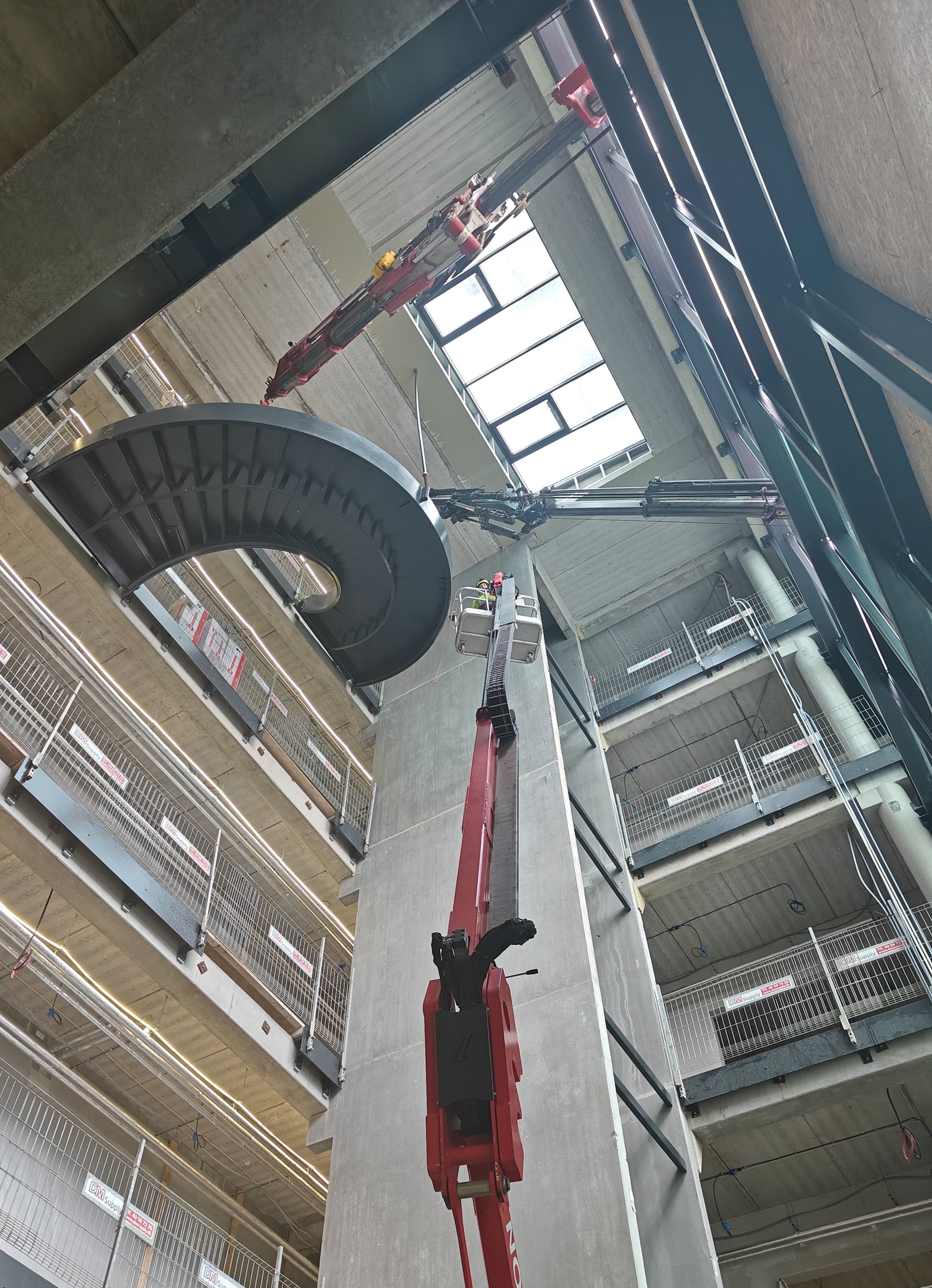 Spindeltrappe hejses op gennem åbning i facade med mobilkran