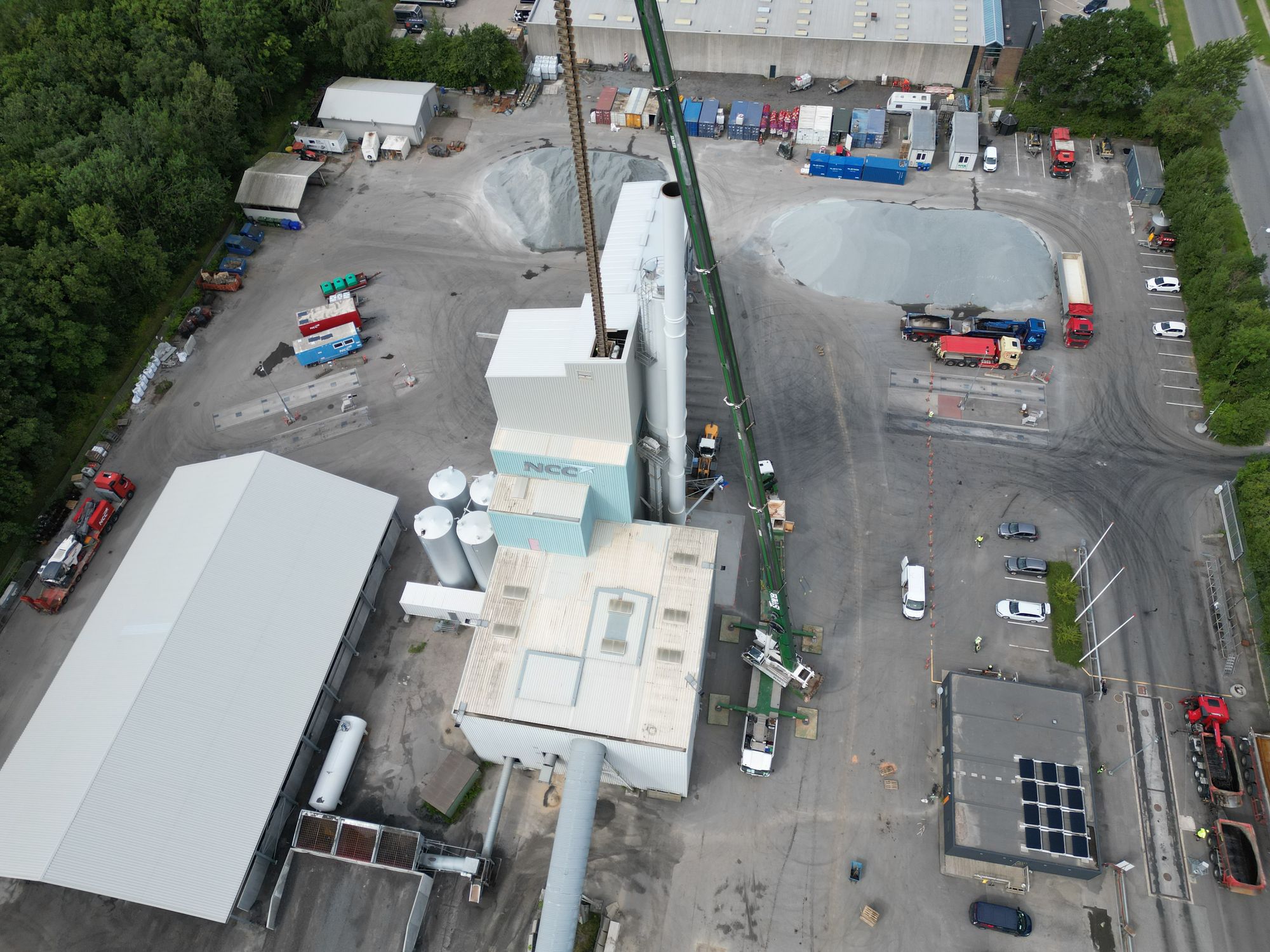 Luftfoto af kran ved industribygning med siloer