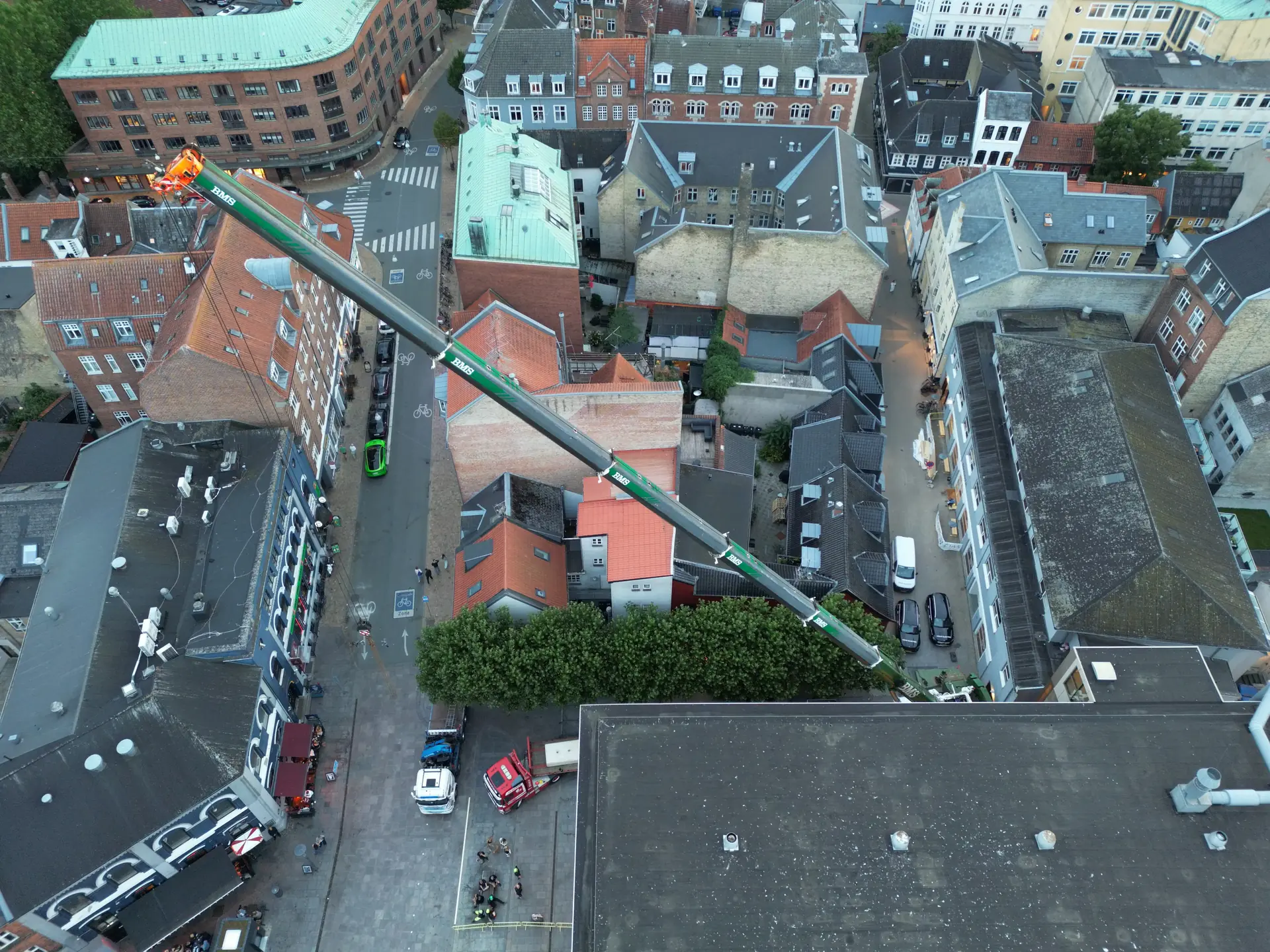Luftfoto af mobilkranens bom, der rækker hen over Magasins bygning i Odense.