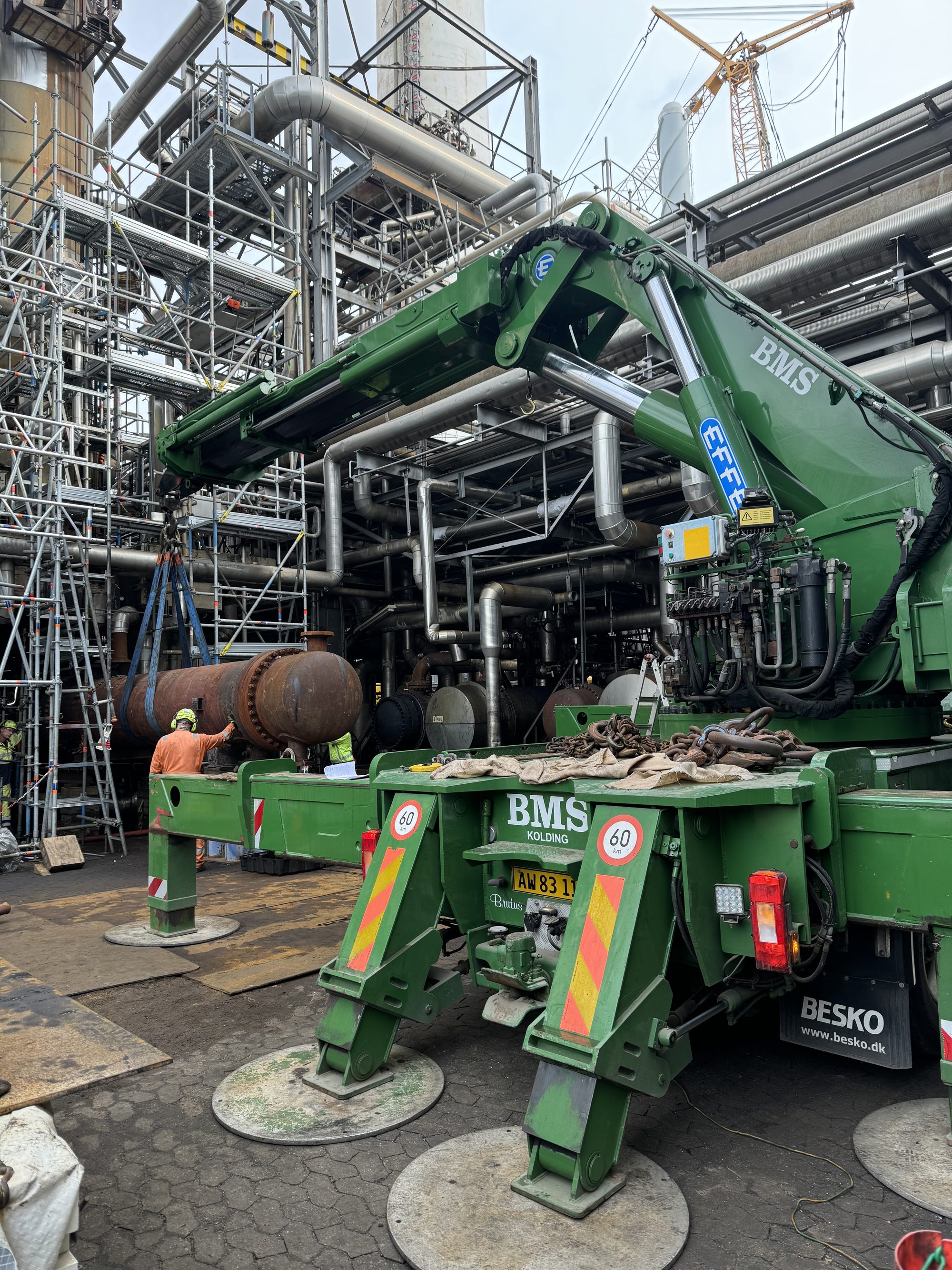 BMS lastbilkran løfter en tung cylindrisk varmeveksler ind mellem stilladser under shutdown