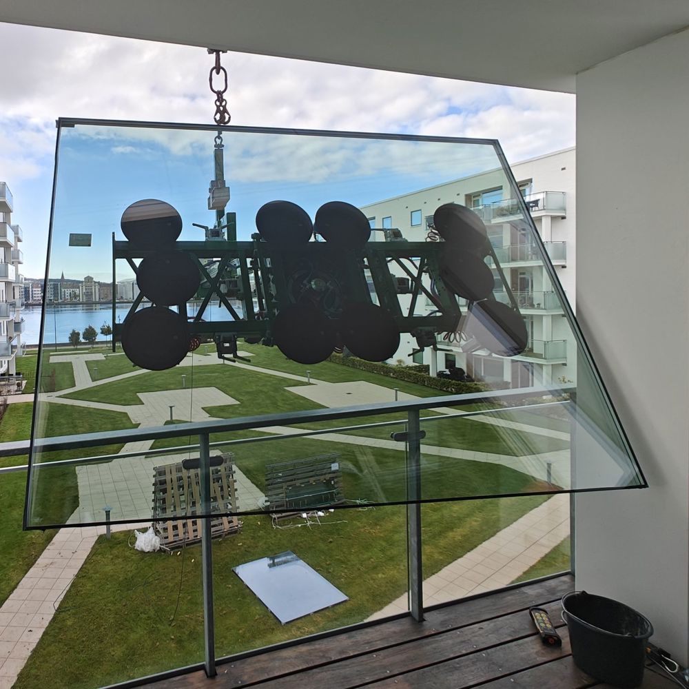 Glasmanipulator holder stort glaselement på plads ved altan