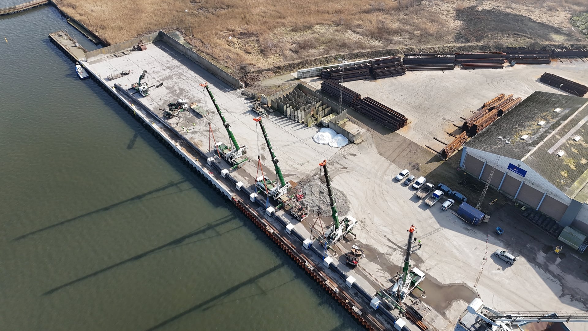Dronefoto over Kolding Havn med BMS kraner ved samløft af langt rør
