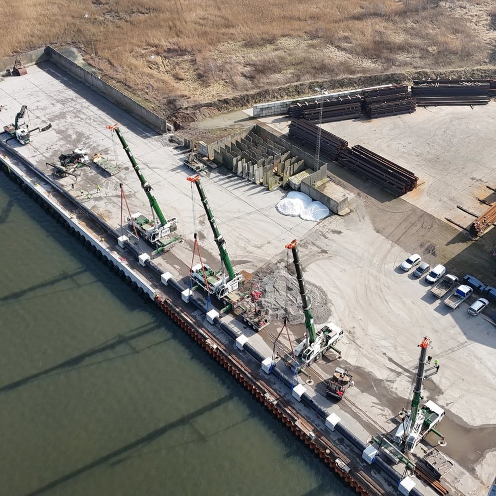 Dronefoto over Kolding Havn med BMS kraner ved samløft af langt rør