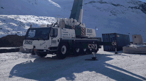 BMS mobilkran i sneen i Grønland med sol bagved