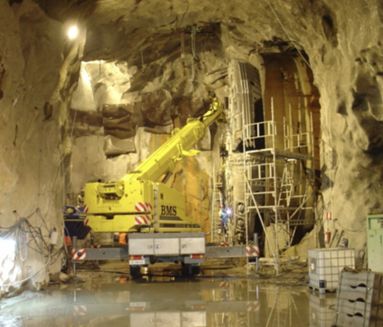 Mobilkran arbejder i tunnel under udskiftning af borskærehoved på boremaskine