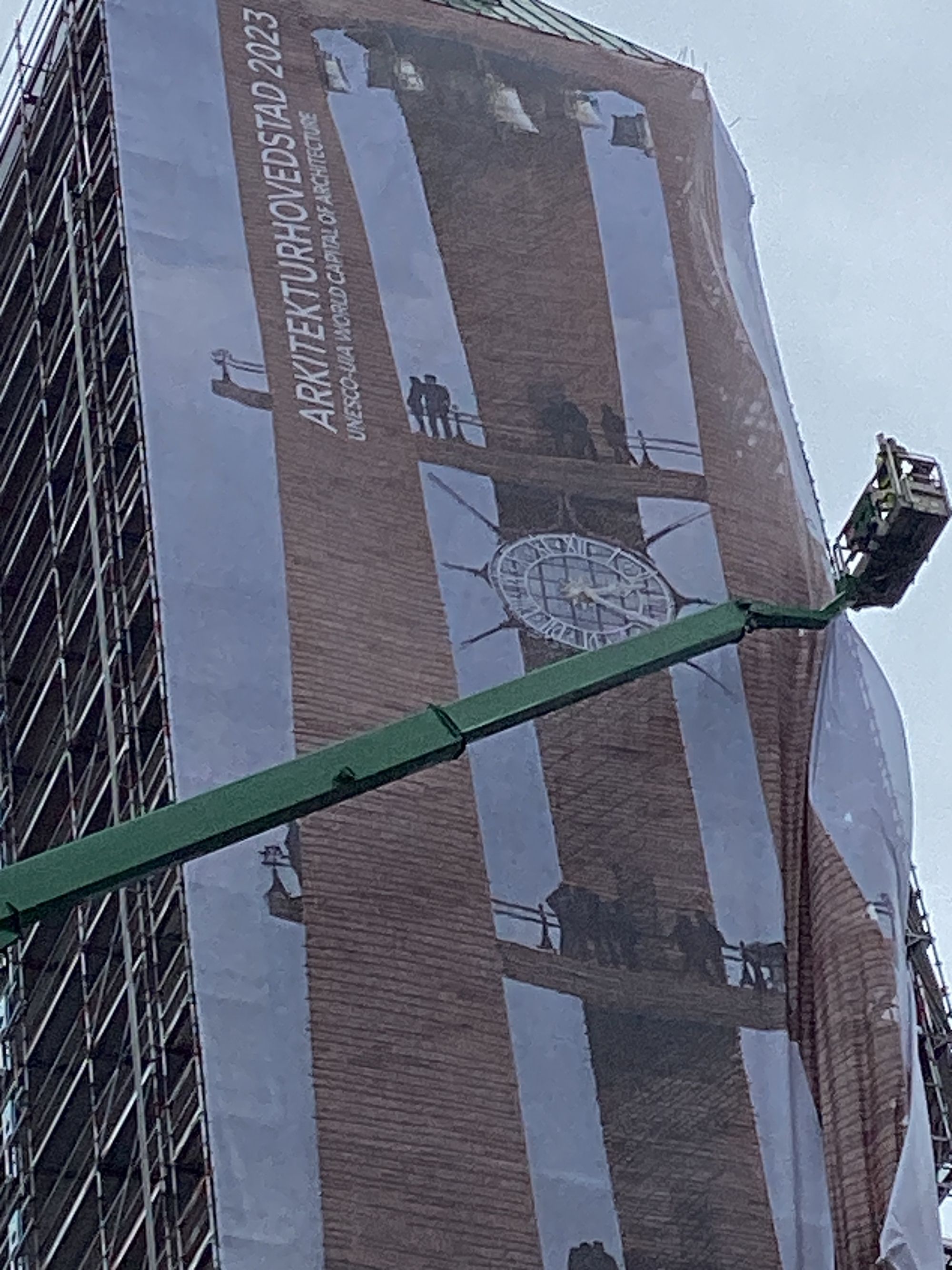 Banner med teksten "Arkitekturhovedstad 2023" monteres på Københavns Rådhustårn